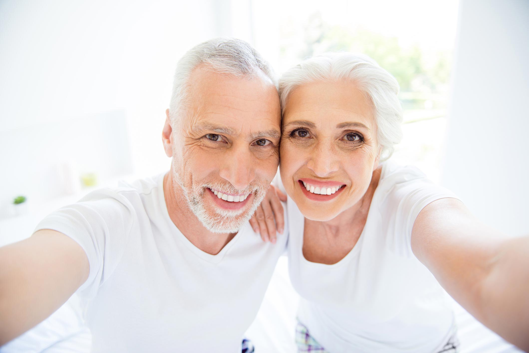 A smiling older couple after comfortable endodontic care